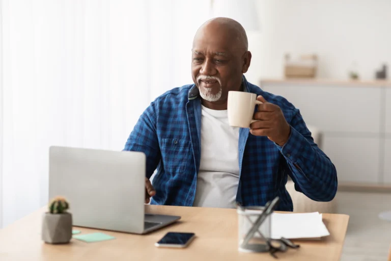 And older gent with a laptop and coffee