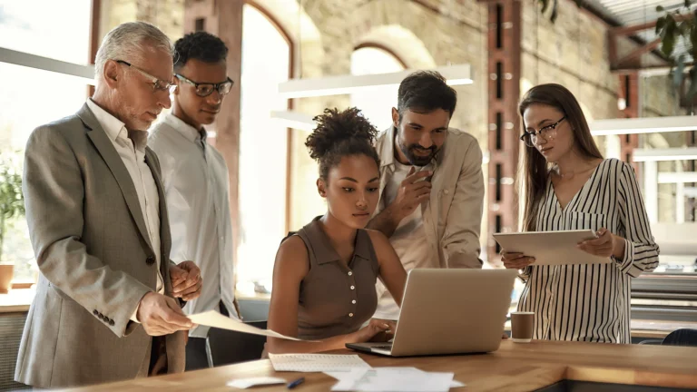 A group in an office reviewing financials on a laptop